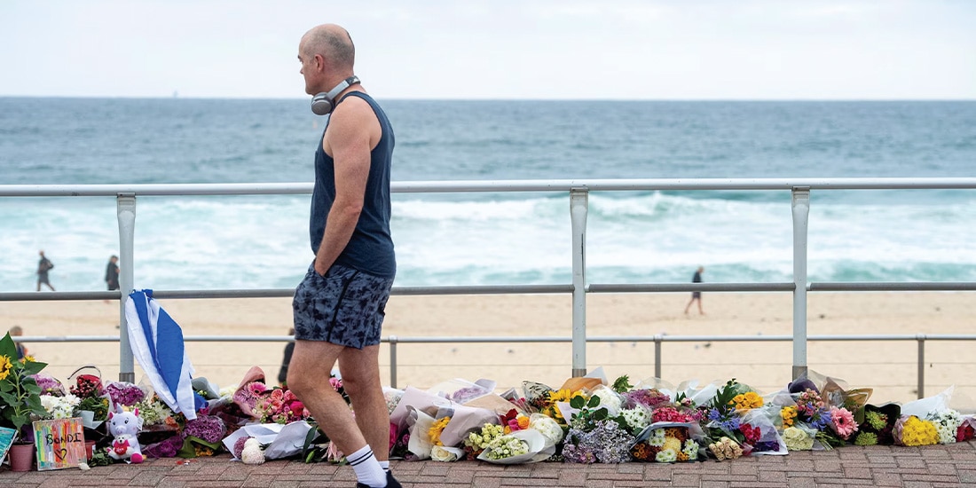 UN HOMBRE pasa junto a tributos florales en honor a las víctimas del tiroteo, ayer.
