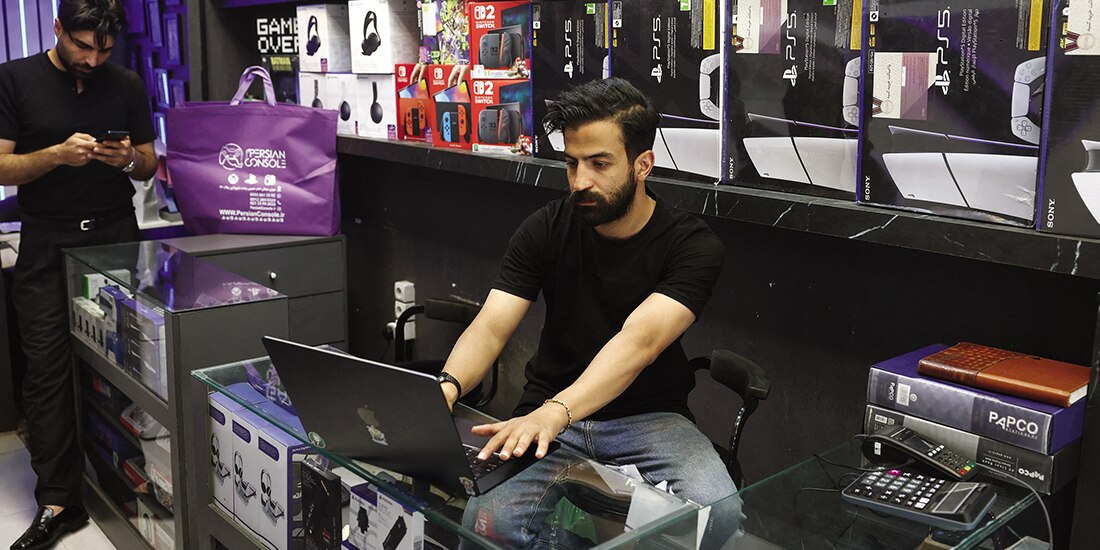 Un vendedor iraní trabaja en una laptop en su tienda, después de una reapertura del acceso internacional a Internet, en Teherán.