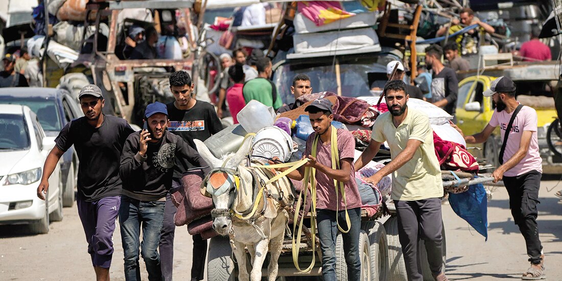 Palestinos desplazados huyen del norte de la Franja de Gaza mientras caminan con sus pertenencias por la carretera costera, ayer.