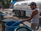 Un trabajador de una pipa de agua suministró botes de habitantes de la Unidad Habitacional Minas Polvorilla Acapatzingo, alcaldía Iztapalapa