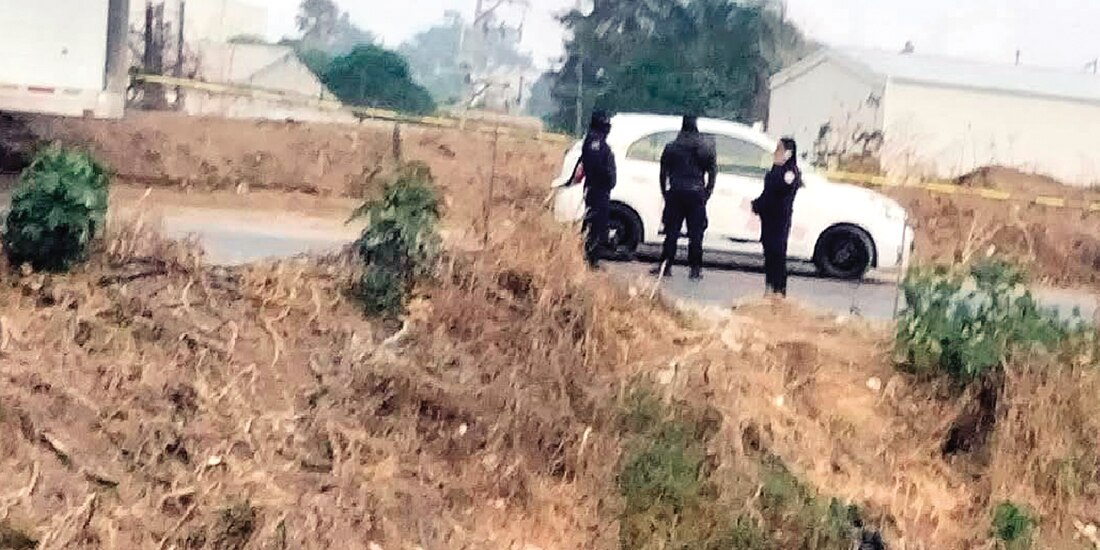 Policías municipales custodian el auto en donde estaban los cuerpos, ayer.