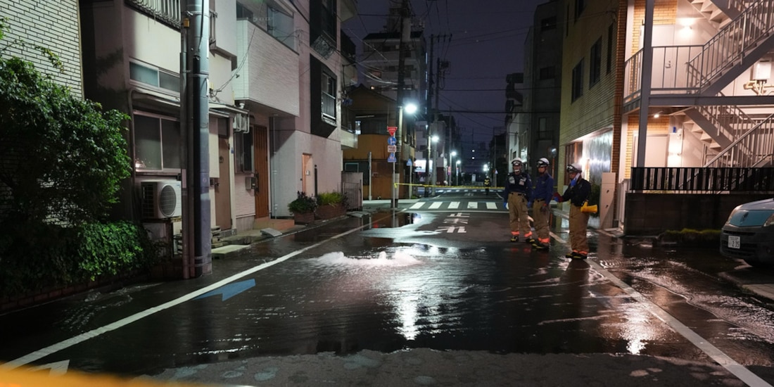 Rescatistas del Departamento de Bomberos de Tokio junto a un camino parcialmente inundado, la madrugada del 23 de agosto de 2026, en Tokio.