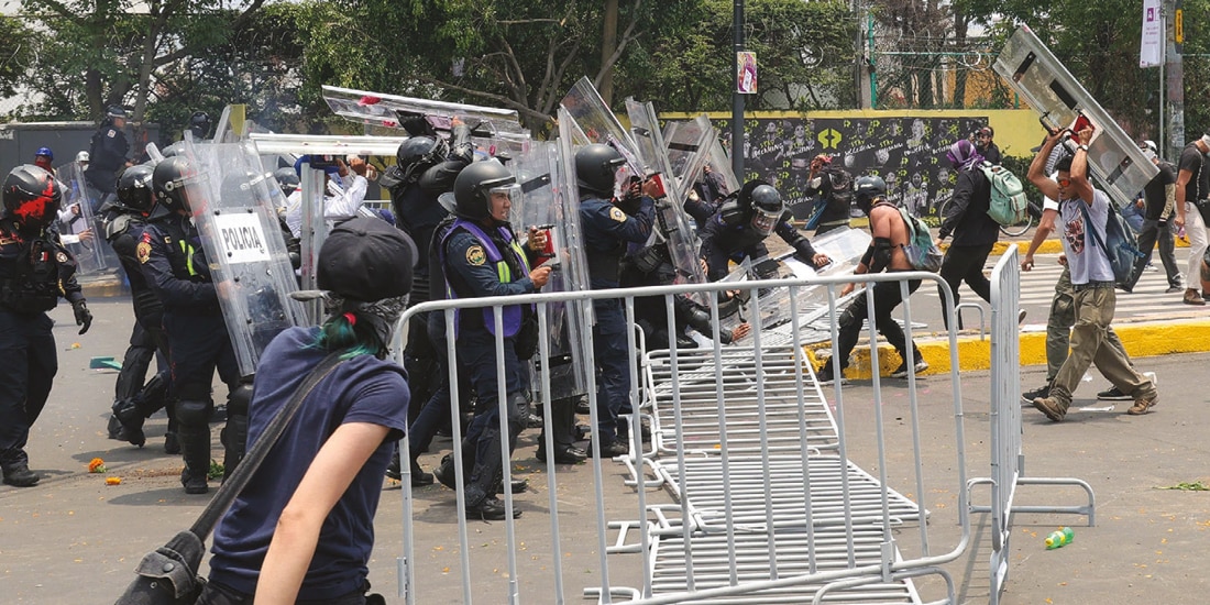 MANIFESTANTES ARROJARON las vallas contra los uniformados, ayer, en la periferia del coloso