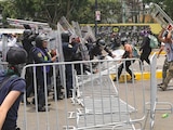 MANIFESTANTES ARROJARON las vallas contra los uniformados, ayer, en la periferia del coloso