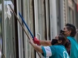 Un par de mujeres trabajan limpiando los cristales de un edificio en Paseo de la Reforma