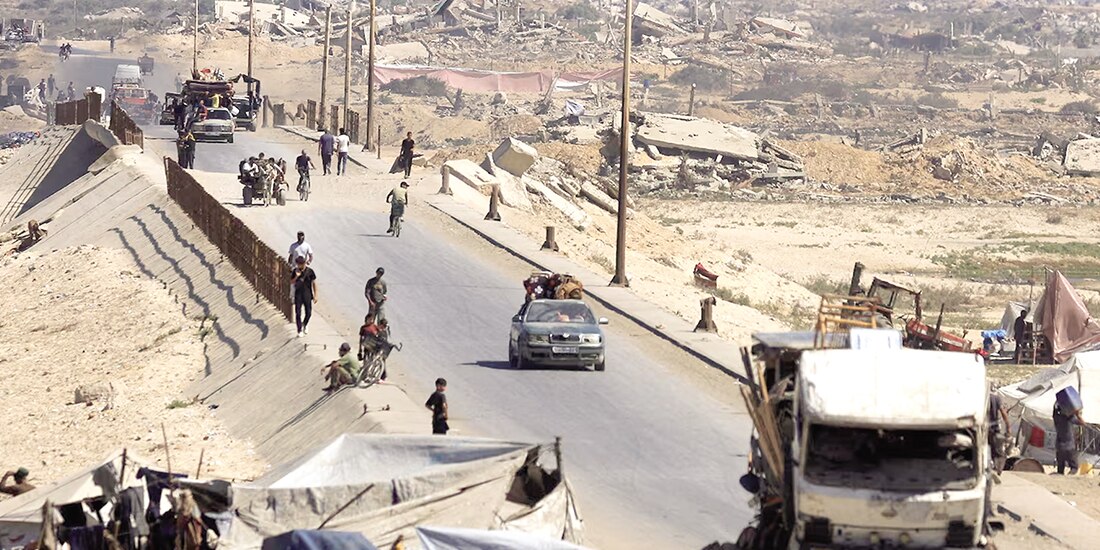 Palestinos desplazados que huyen del norte de Gaza se desplazan hacia el sur, en la capital, ayer.